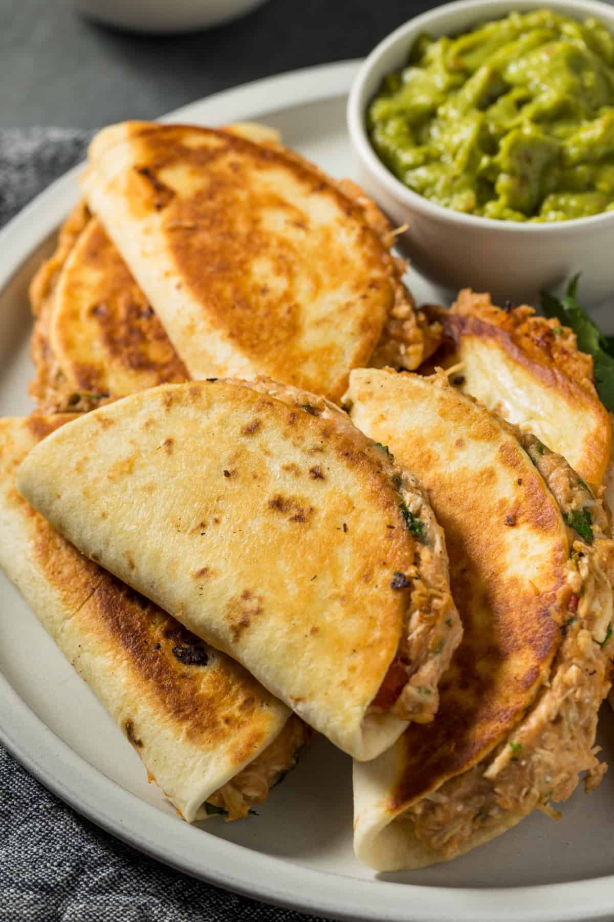 Chicken breast is slow cooked in salsa verde then shredded to make this Crockpot Salsa Verde Chicken. Easy dinner idea! Salsa verde chicken tacos on a plate