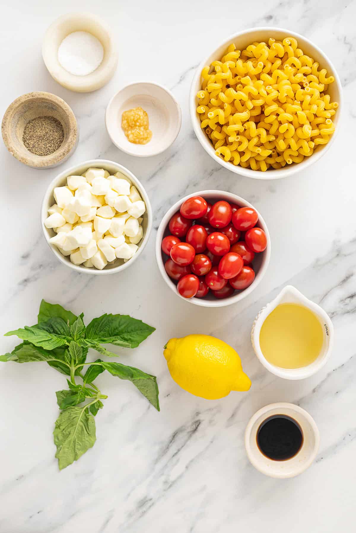 Overhead view of ingredients needed to make caprese pasta salad