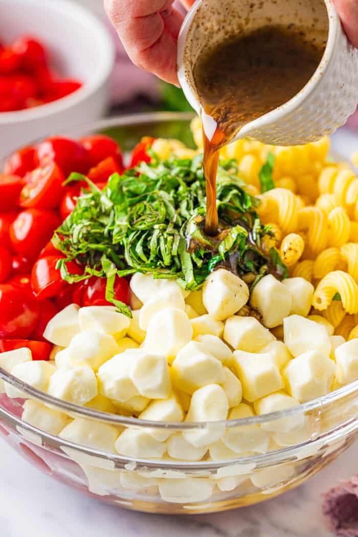 Fresh mozzarella, tomatoes, basil, and pasta are tossed with a lemony vinaigrette in this Caprese Pasta Salad. Drizzling dressing over the pasta ingredients