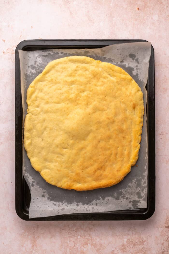 Baked cottage cheese pizza crust on a baking sheet