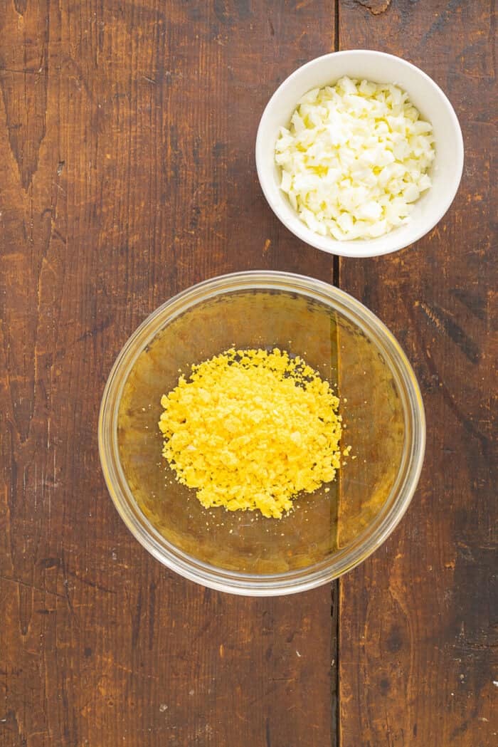 Overhead view of bowls of diced egg whites and egg yolk