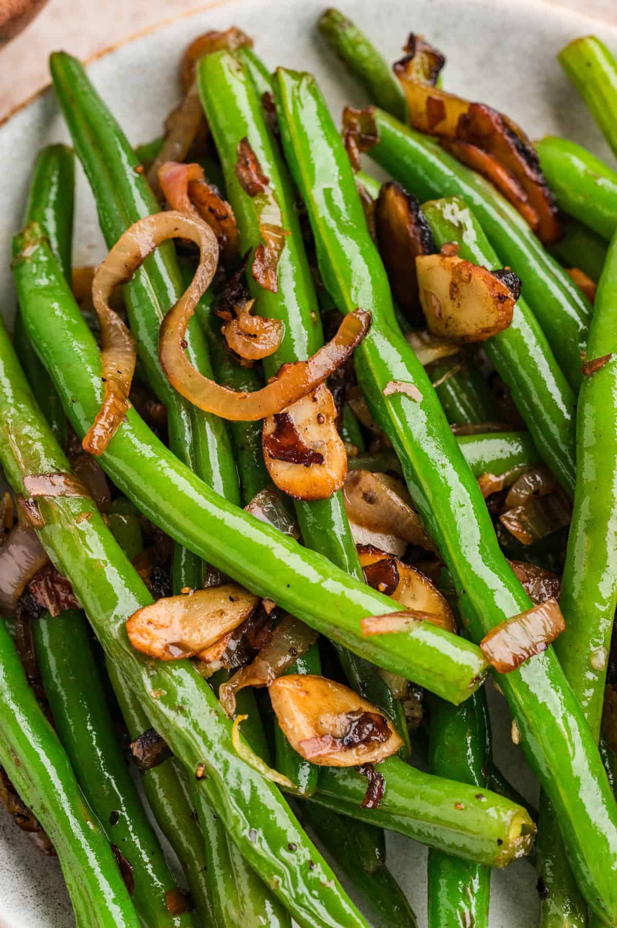 These Green Beans Almondine are a quick and easy side dish made with tender crisp green beans, buttery shallots, and toasted almonds. Close up of green beans almondine