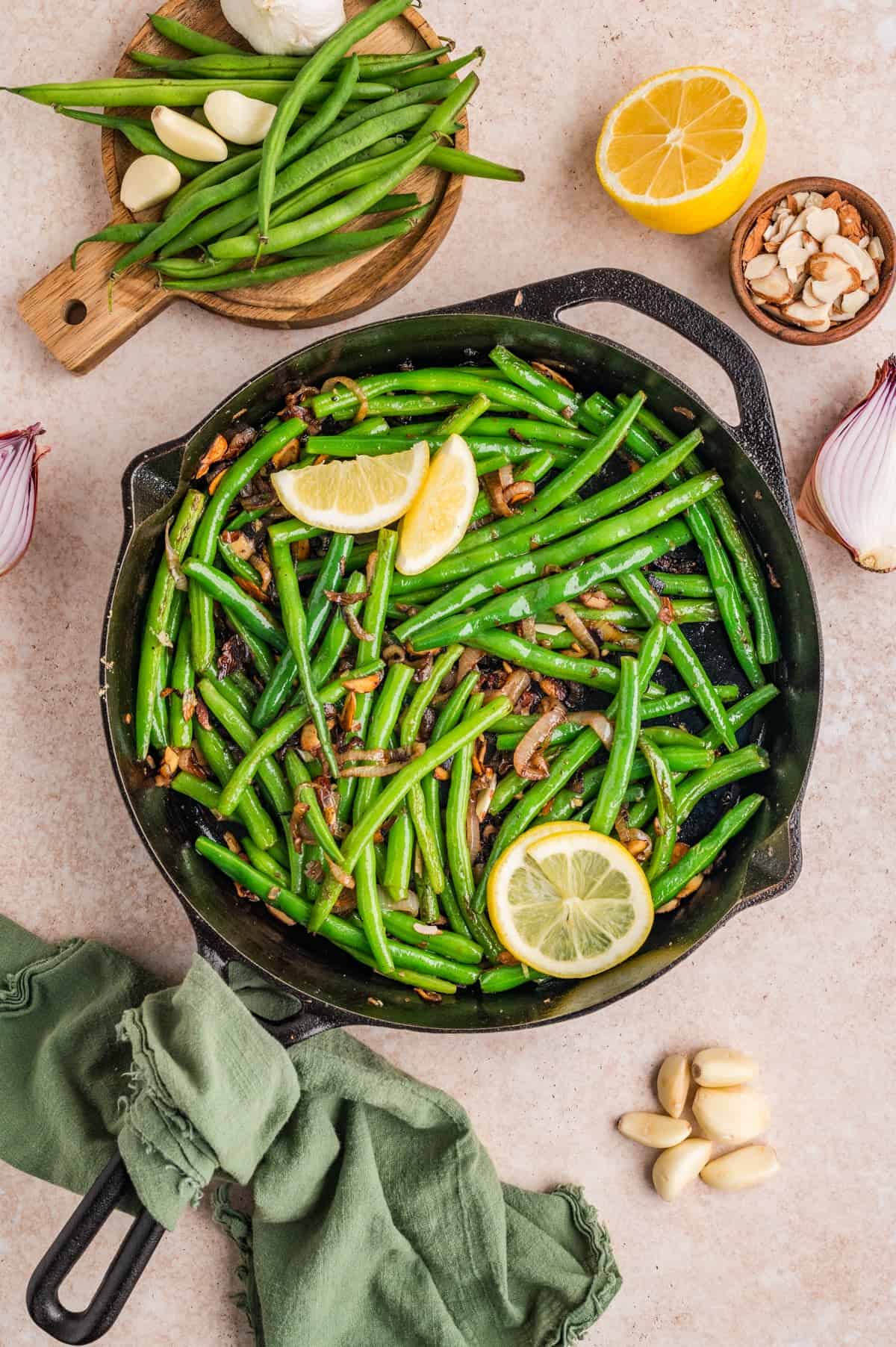 These Green Beans Almondine are a quick and easy side dish made with tender crisp green beans, buttery shallots, and toasted almonds. Overhead view of green beans almondine in a skillet