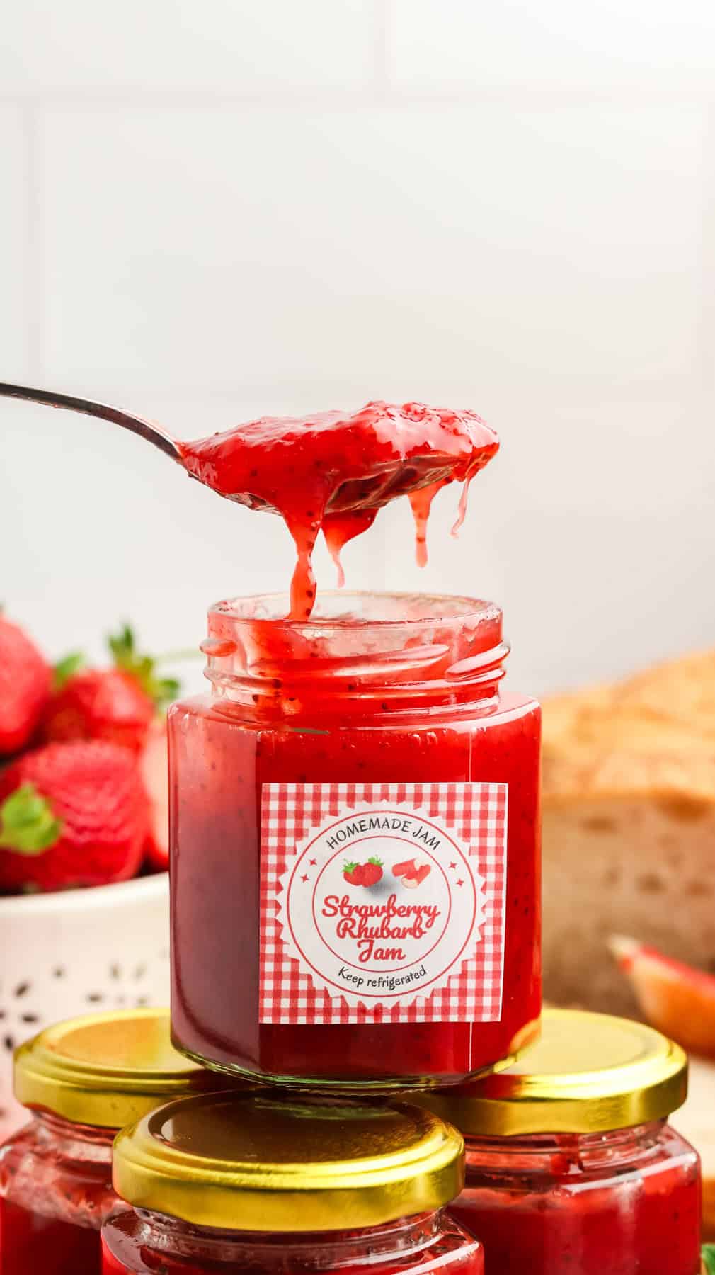 A spoonful of strawberry rhubarb jam over a jar 