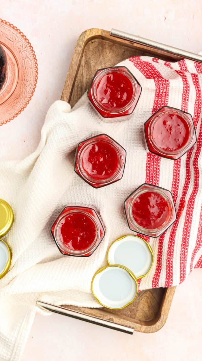 Strawberry rhubarb jam ladled into jars