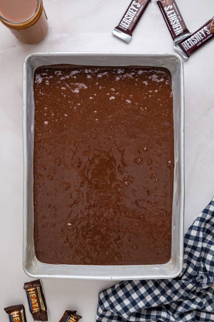 Chocolate cake is drizzled with sweetened condensed milk, caramel sauce, and whipped topping to make this decadent Better Than Sex Cake. Chocolate cake batter in a pan