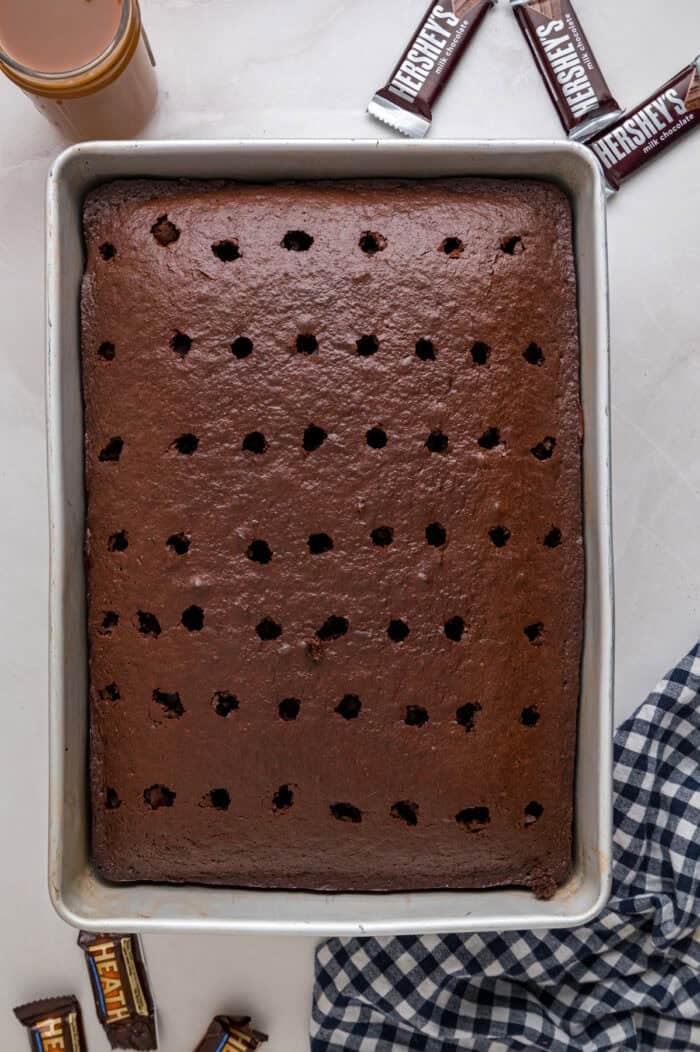 Chocolate cake is drizzled with sweetened condensed milk, caramel sauce, and whipped topping to make this decadent Better Than Sex Cake. Chocolate cake with holes poked in it