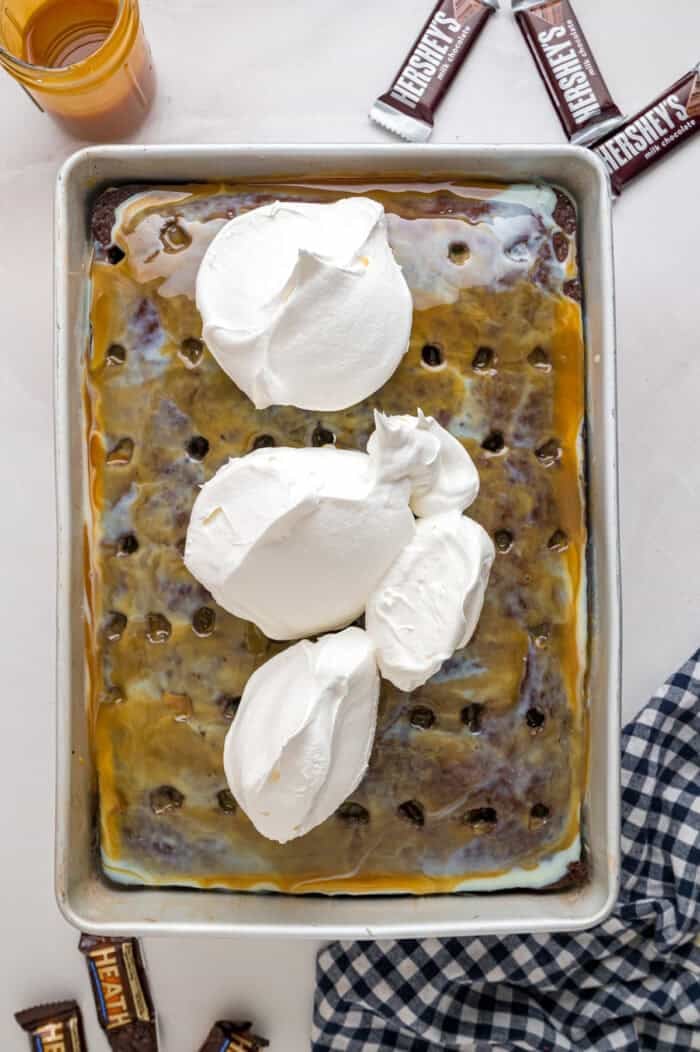 Chocolate cake is drizzled with sweetened condensed milk, caramel sauce, and whipped topping to make this decadent Better Than Sex Cake. Dollops of whipped cream on top of the cake