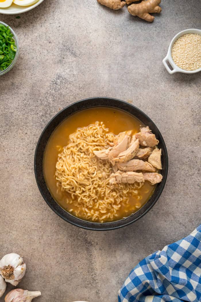 This easy Chicken Ramen recipe turns instant ramen noodles into a flavorful and filling weeknight dinner. Ready in 35 minutes! Ramen noodles and chicken in a black bowl