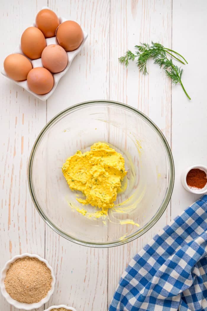 Fried Deviled Eggs are a fun twist on the classic, with hard-boiled egg whites coated in breadcrumbs and deep-fried. Mashed egg yolks in a bowl