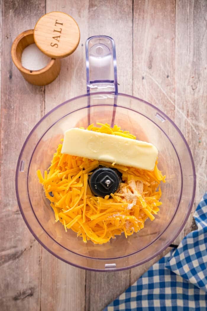 Shredded cheddar and butter in a food processor