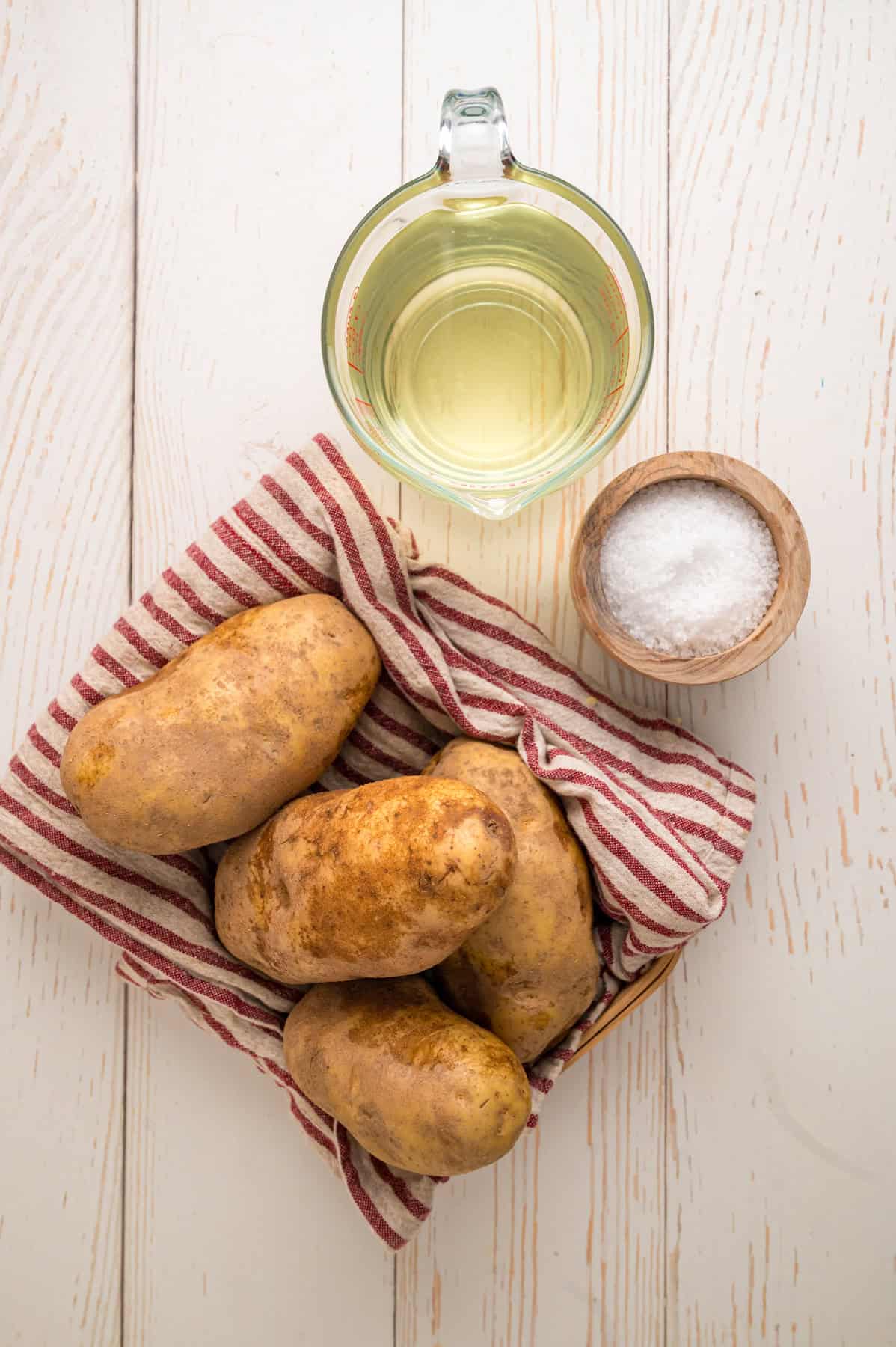 These easy homemade French Fries are made with just Russet potatoes, salt, and oil. Tender on the inside and crispy on the outside! Overhead view of ingredients needed to make homemade French fries