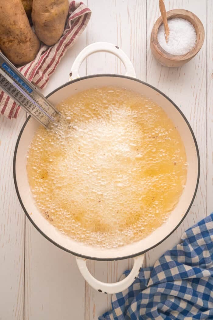 These easy homemade French Fries are made with just Russet potatoes, salt, and oil. Tender on the inside and crispy on the outside! Oil bubbling in a pot for frying