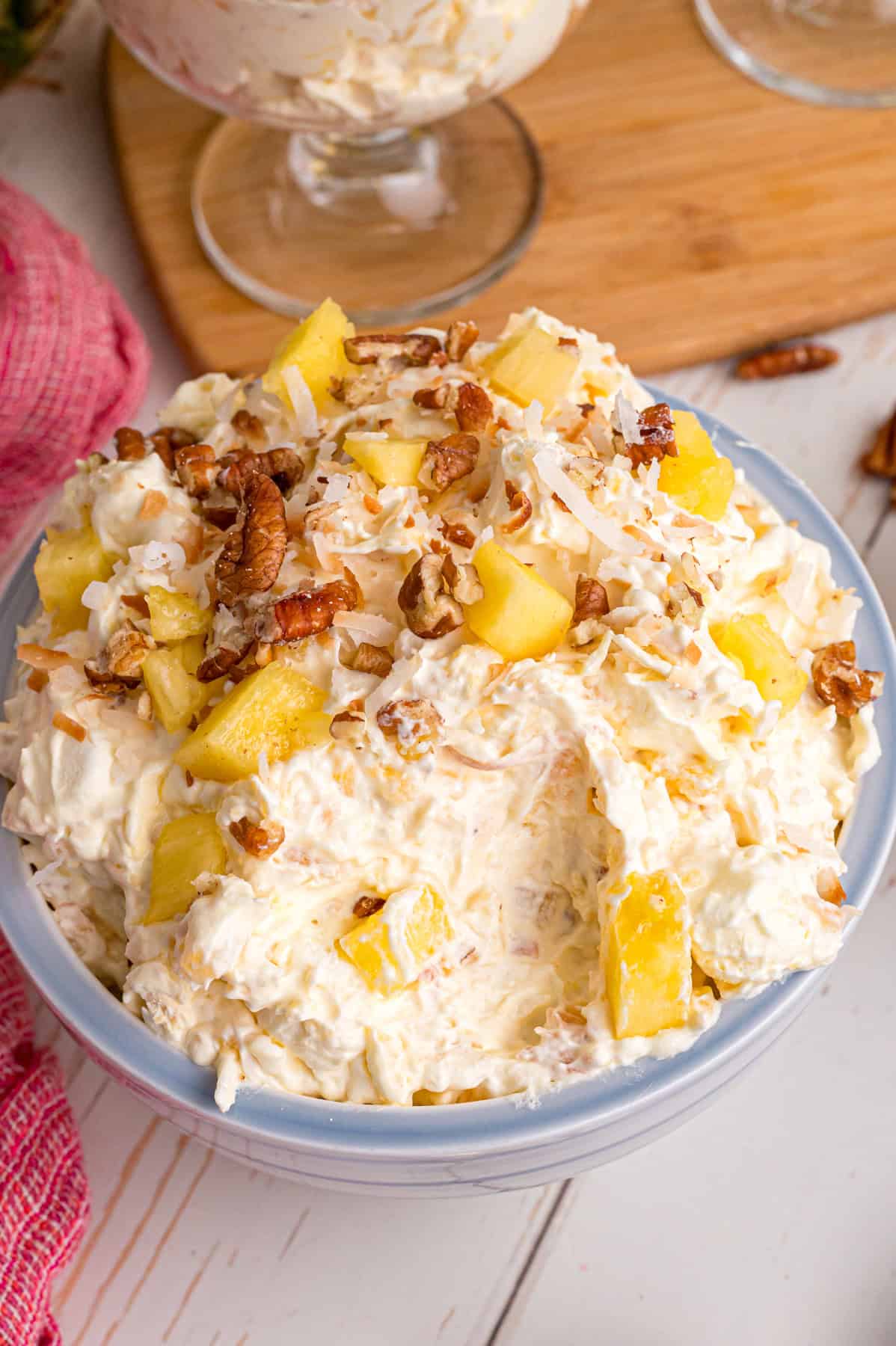 Pineapple Fluff is a quick and easy no-bake dessert that’s perfect for summer, with crushed pineapple, toasted coconut, and marshmallows. A bowl of pineapple fluff with a few spoonfuls missing