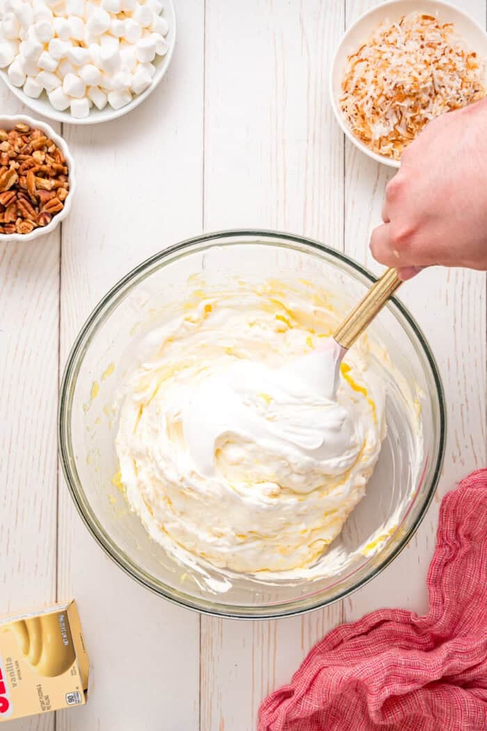 Pineapple Fluff is a quick and easy no-bake dessert that’s perfect for summer, with crushed pineapple, toasted coconut, and marshmallows. Folding whipped topping into the pineapple pudding mixture