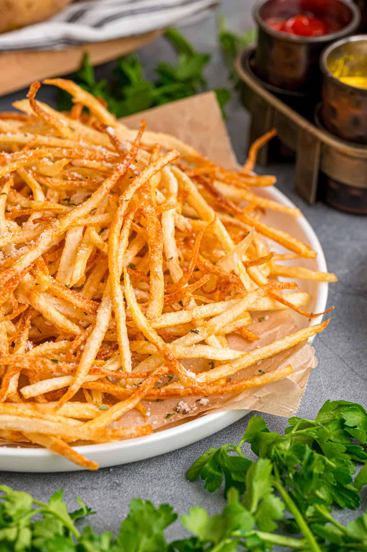 Made with just 3 ingredients, these Shoestring Fries are long, thin, and fry in just a few minutes. Serve with your favorite dipping sauces. Side view of a plate of shoestring fries