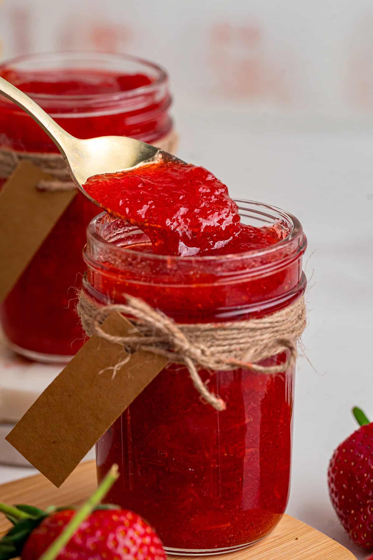 A spoon in a jar of strawberry jam