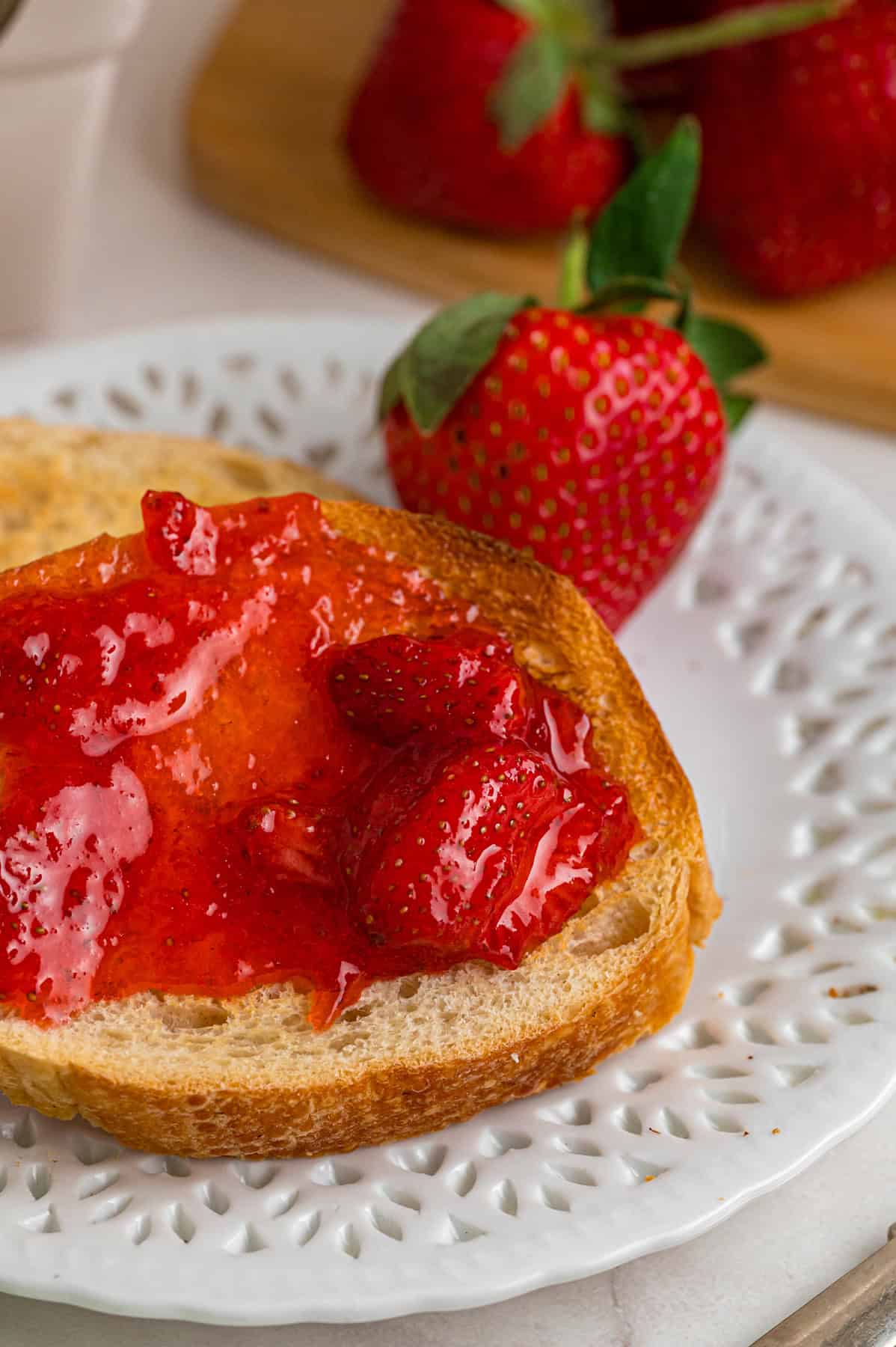 Made with just 4 ingredients, this Strawberry Jam recipe is quick and easy to make with no canning equipment required. Strawberry jam spread on a slice of toast