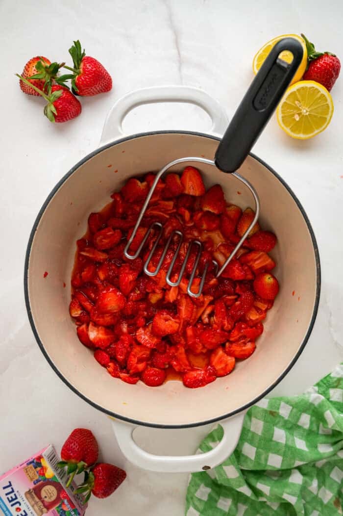 Made with just 4 ingredients, this Strawberry Jam recipe is quick and easy to make with no canning equipment required. Mashing sliced strawberries with a potato masher