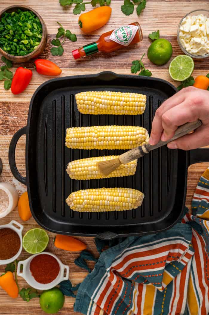 Charred corn kernels, feta cheese, and pasta are tossed in a creamy dressing to make this Street Corn Pasta Salad. Brushing corn cobs with oil