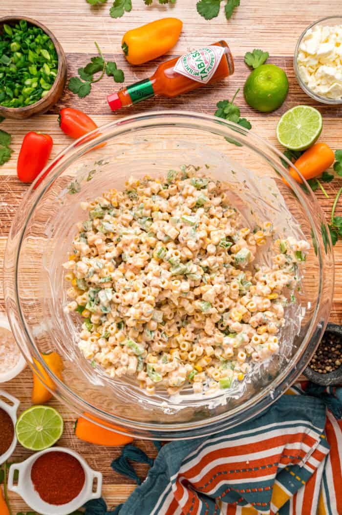 Charred corn kernels, feta cheese, and pasta are tossed in a creamy dressing to make this Street Corn Pasta Salad. Overhead view of street corn pasta salad in a bowl
