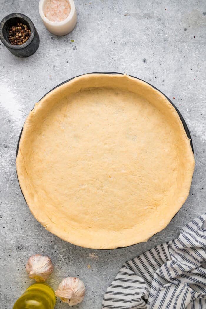 Pizza dough shaped into a deep dish pan