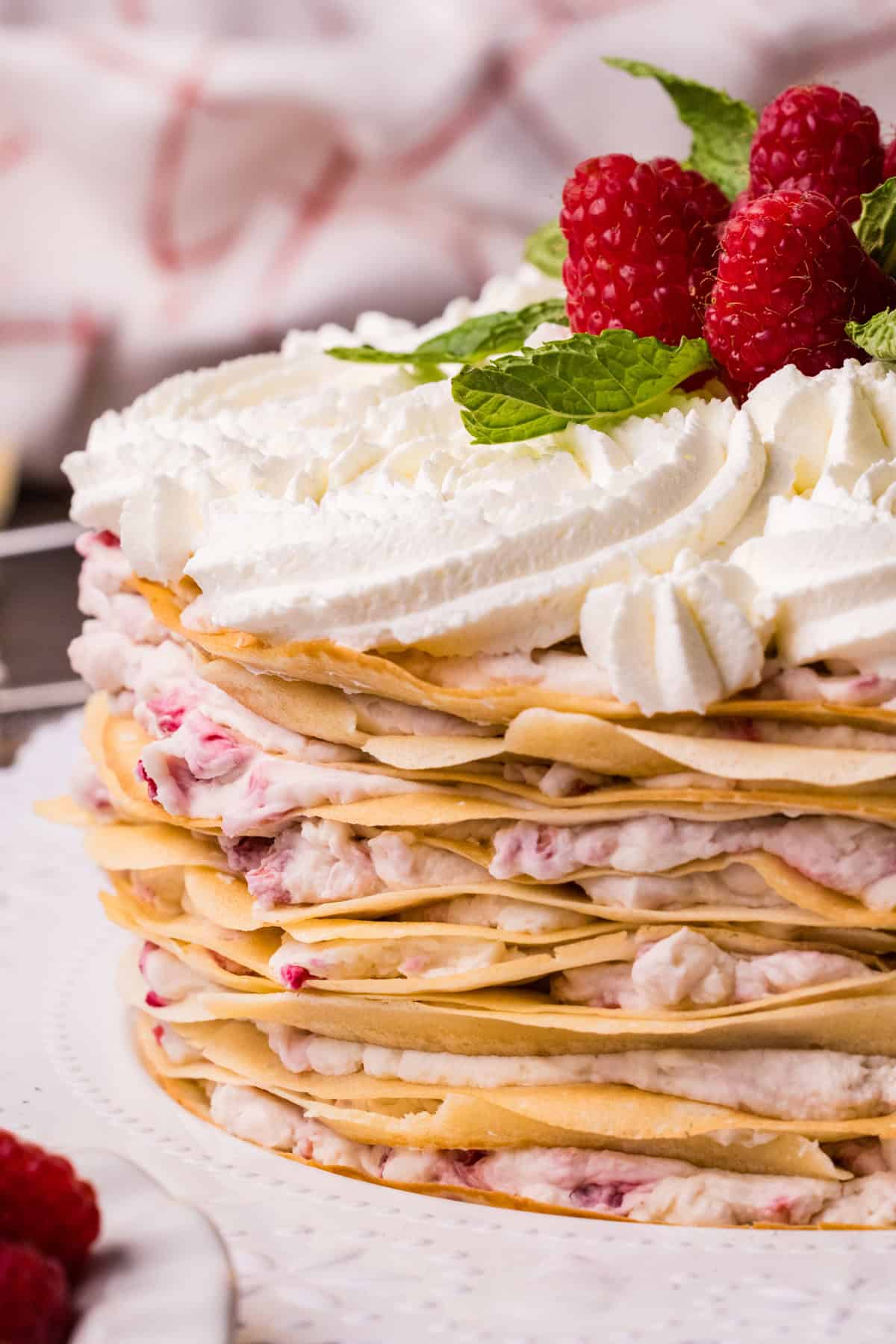 Mille crepe cake with raspberry filling on a white plate