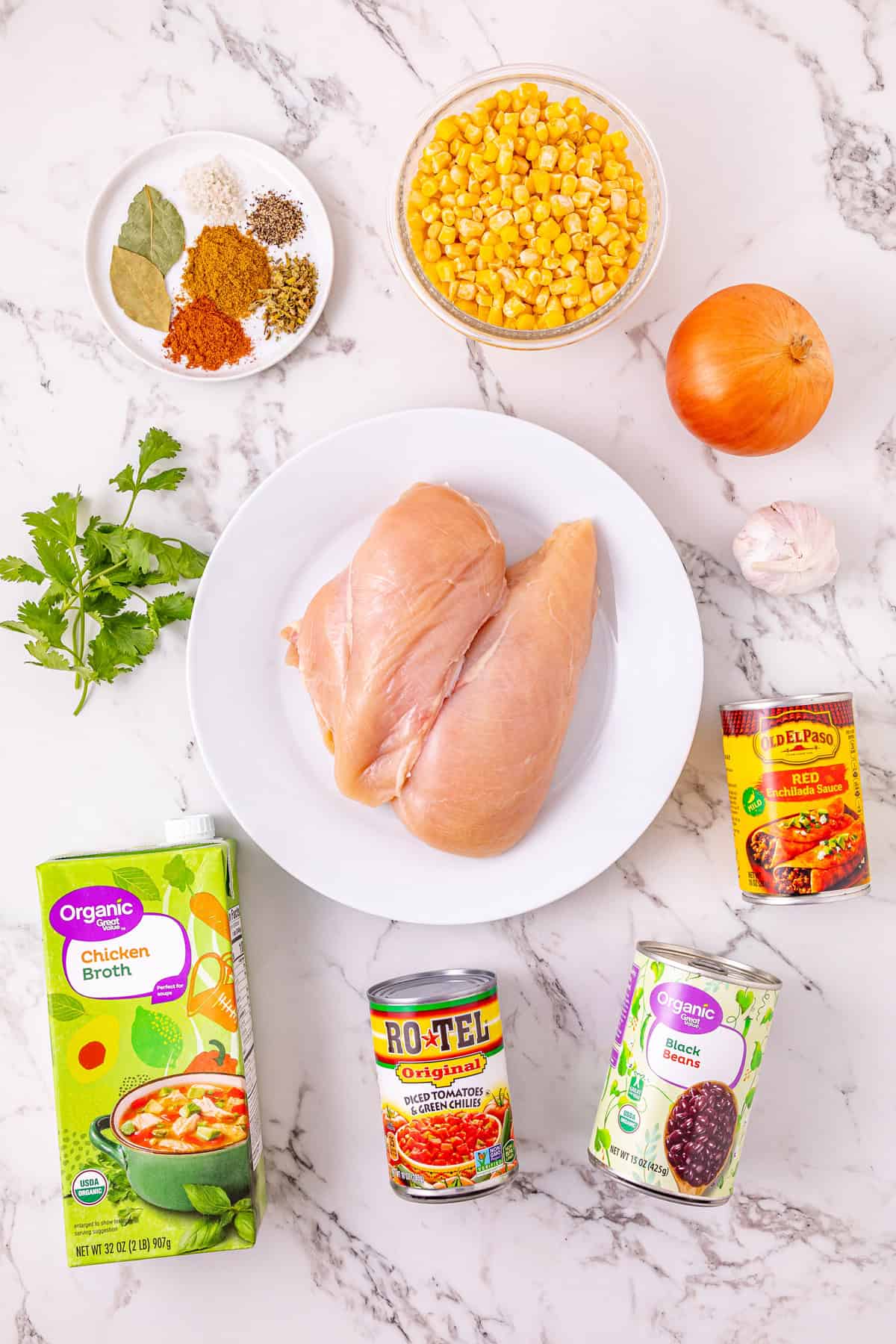 Chicken, beans, diced tomatoes and green chilies, and corn are slow-cooked in enchilada sauce broth to make Crockpot Chicken Enchilada Soup. Overhead view of ingredients needed to make crockpot chicken enchilada soup