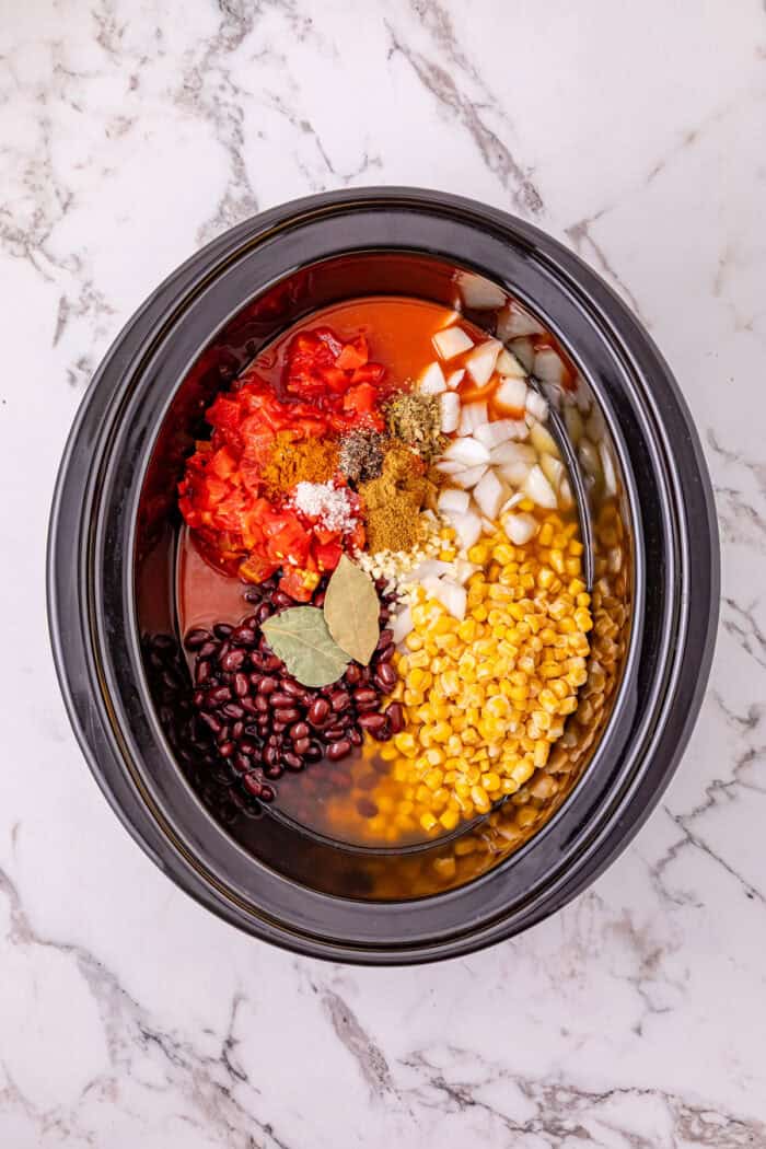 Chicken, beans, diced tomatoes and green chilies, and corn are slow-cooked in enchilada sauce broth to make Crockpot Chicken Enchilada Soup. Ingredients to make chicken enchilada soup in the crockpot