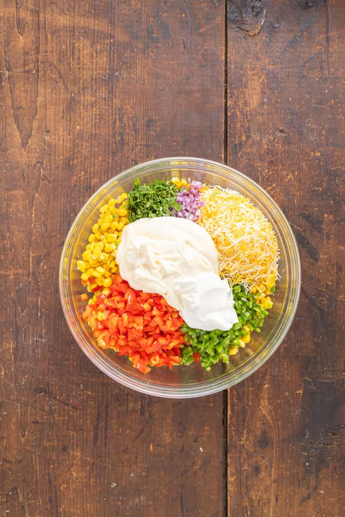 Frito Corn Salad is fun, flavorful, and the perfect combination of crunchy and creamy, with diced veggies and crushed Fritos. Sour cream and mayo added to te veggies