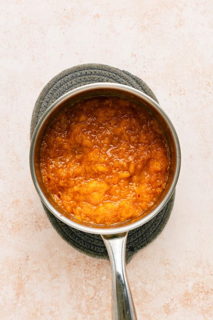 Fresh peaches are turned into a compote and swirled into a mixture of sweetened condensed milk & heavy cream in this No-Churn Peach Ice Cream. Peach compote in a saucepan
