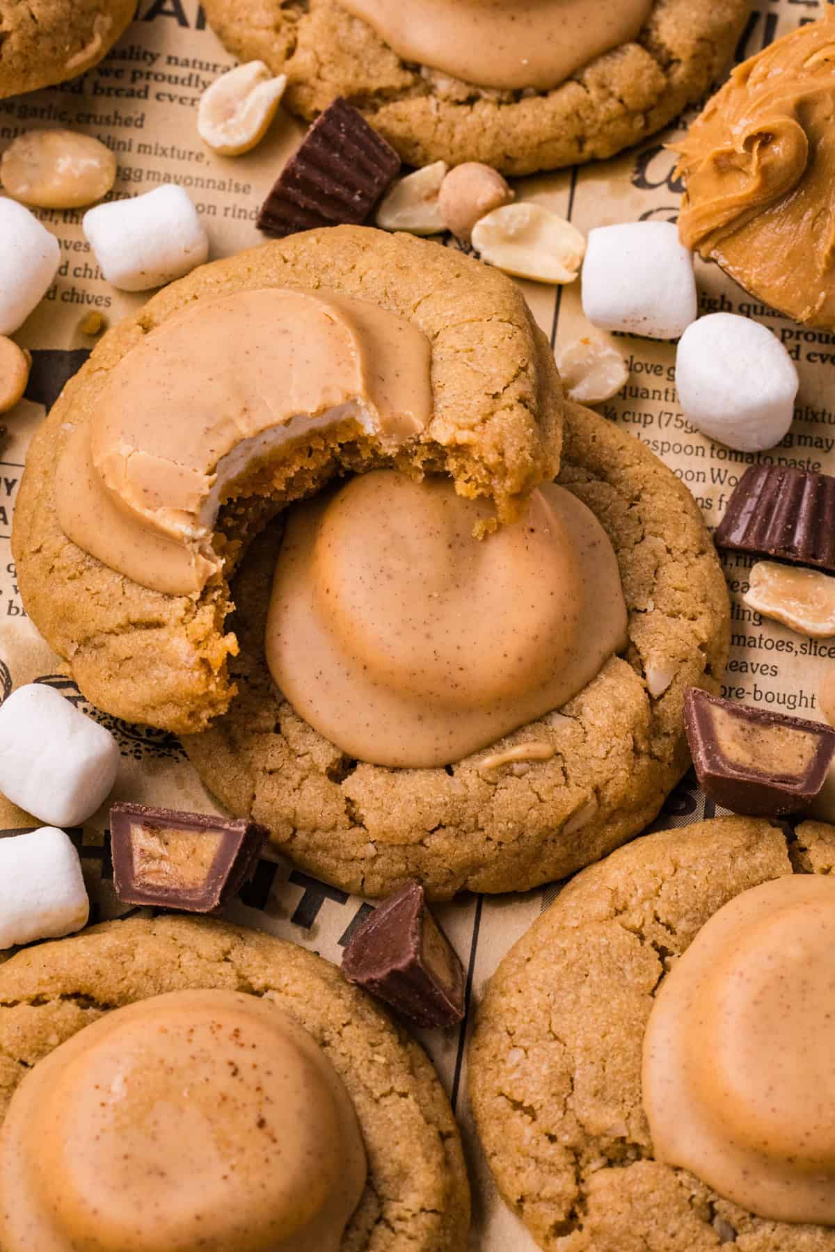 These soft and chewy Peanut Butter Marshmallow Cookies are loaded with rich peanut butter flavor and a marshmallow surprise. A peanut butter marshmallow cookie with a bite missing on top of other cookies