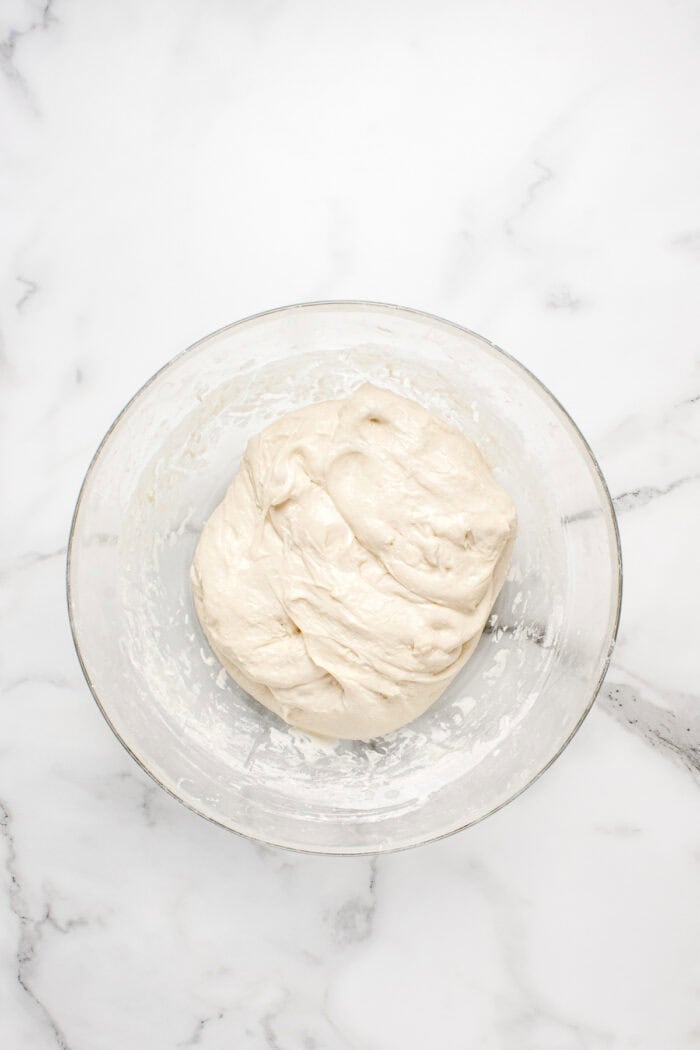 Made with an active sourdough starter, pantry staples, and a simple process, this Sourdough Bread recipe is perfect for beginners. Sourdough bread dough in a glass bowl