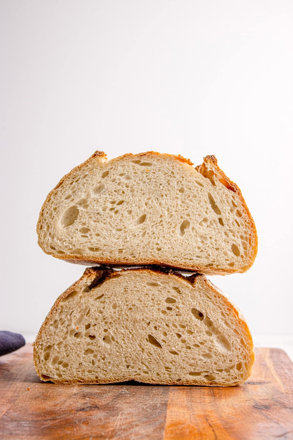 Made with an active sourdough starter, pantry staples, and a simple process, this Sourdough Bread recipe is perfect for beginners. Two halves of a sourdough bread loaf stacked on each other