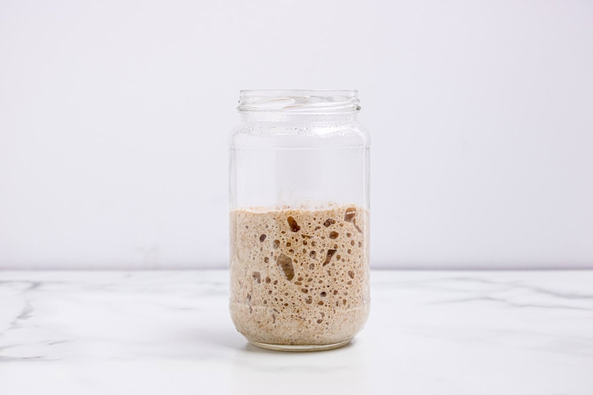 This easy sourdough starter recipe walks you through the process day-by-day with images. Great for beginners! A glass jar with active sourdough starter