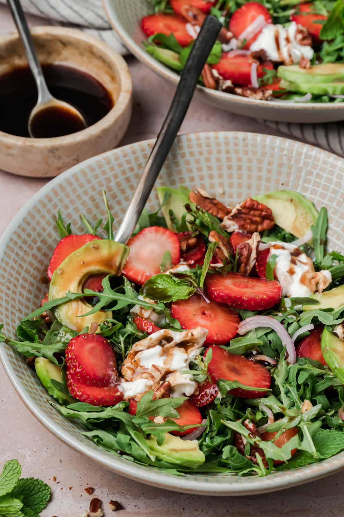 Strawberry Arugula Salad is perfect for summer, with peppery arugula, fresh strawberries, creamy burrata, crunchy pecans & avocado. A bowl of strawberry arugula salad