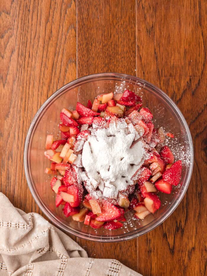 Tapioca and cornstarch added to a bowl with strawberry and rhubarb