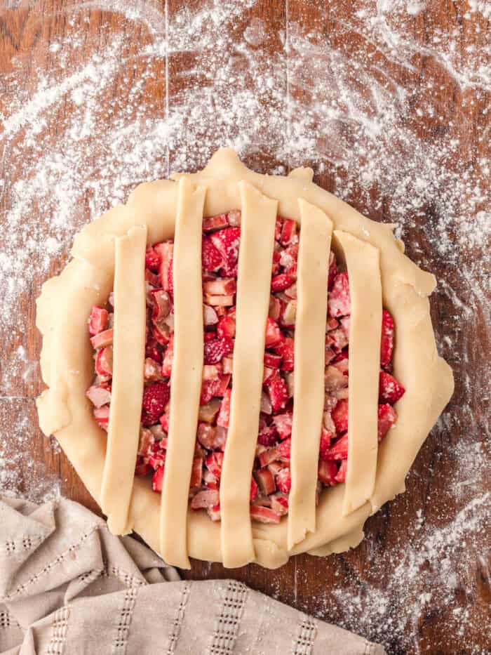 Vertical strips of pie crust over strawberry rhubarb filling