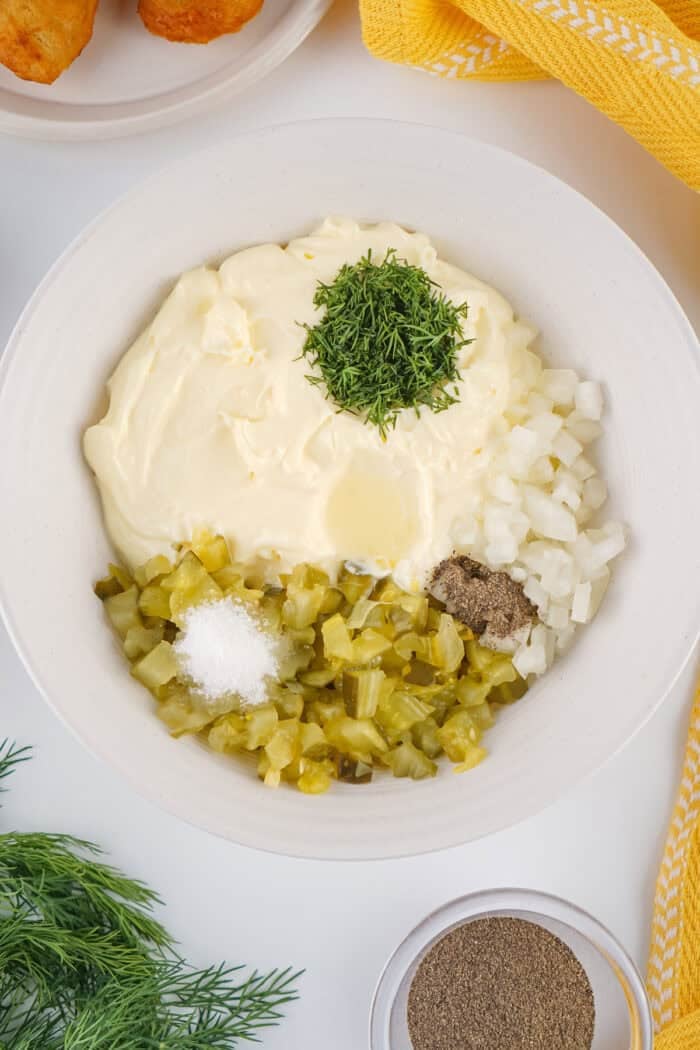 This easy Homemade Tartar Sauce recipe combines fresh dill, mayo, and pickles to create a creamy, tangy dip for seafood. Ingredients for tartar sauce in a bowl