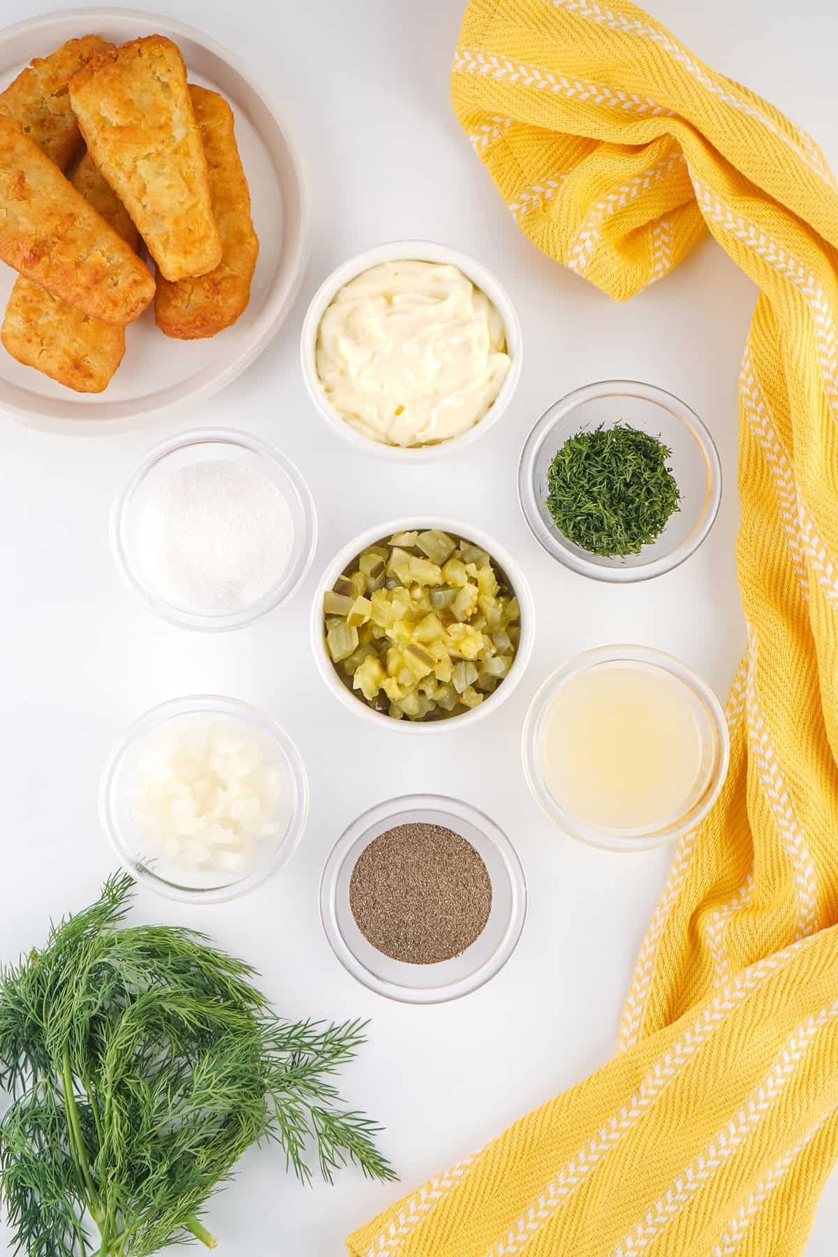 This easy Homemade Tartar Sauce recipe combines fresh dill, mayo, and pickles to create a creamy, tangy dip for seafood. Overhead view of the ingredients needed to make homemade tartar sauce