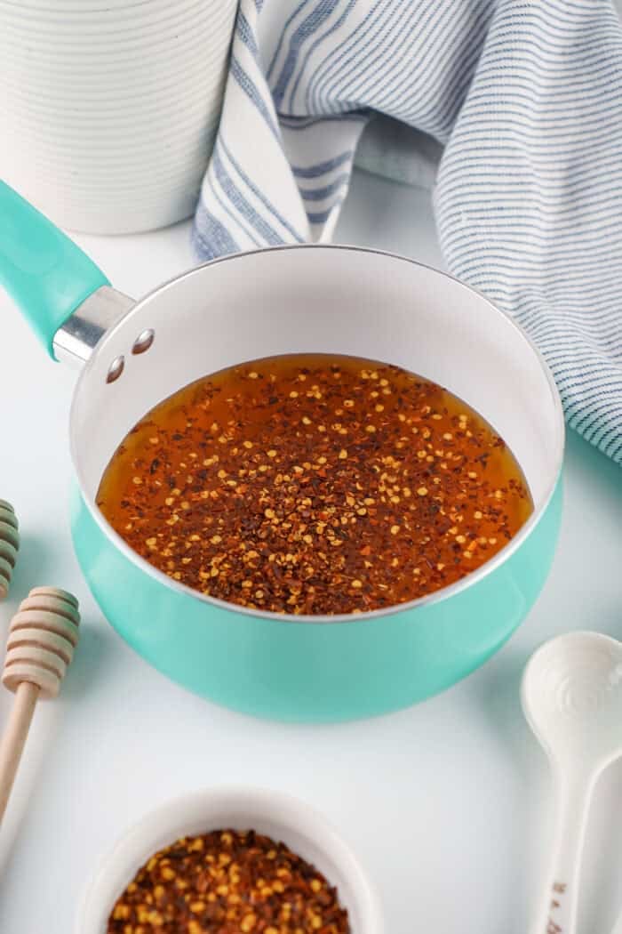 This Hot Honey recipe is made with just 3 ingredients in 7 minutes. It’s ridiculously easy and so much cheaper than buying it at the store. Homemade hot honey in a saucepan