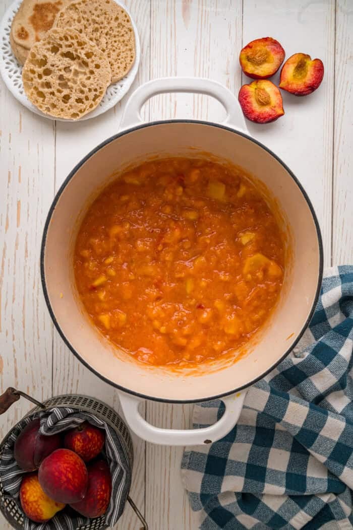 Diced peaches and pectin simmering on the stove