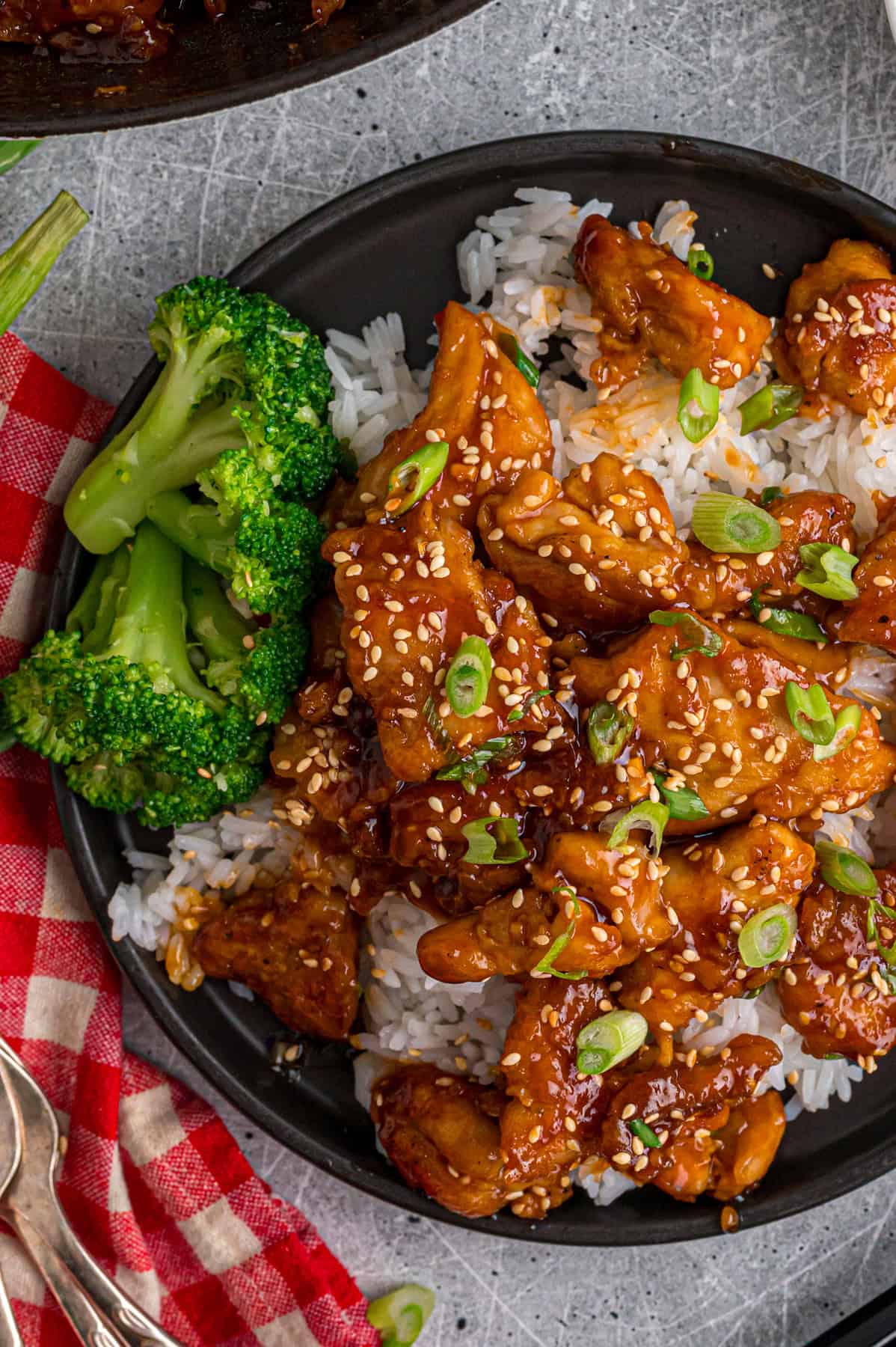 Overhead view of a plate of sesame chicken with rice and broccoli