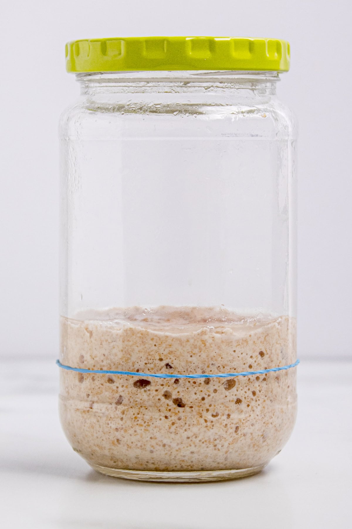 This easy sourdough starter recipe walks you through the process day-by-day with images. Great for beginners! Sourdough starter on day 4 with little rise