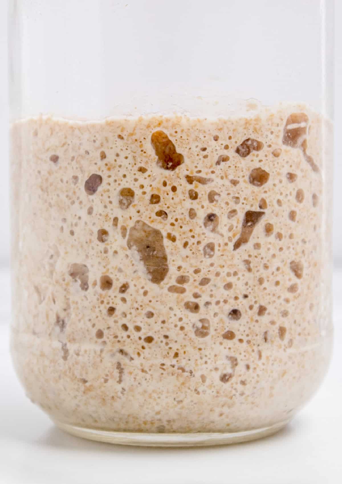 This easy sourdough starter recipe walks you through the process day-by-day with images. Great for beginners! A glass jar with sourdough starter