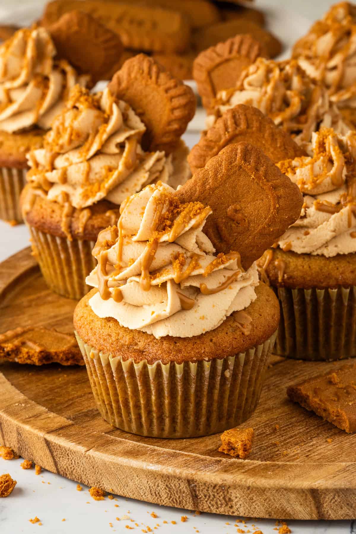 These Biscoff Cupcakes are soft, ultra-moist, and packed with warm caramelized flavor from cookie butter in both the batter and frosting. Biscoff cupcakes on a wooden tray