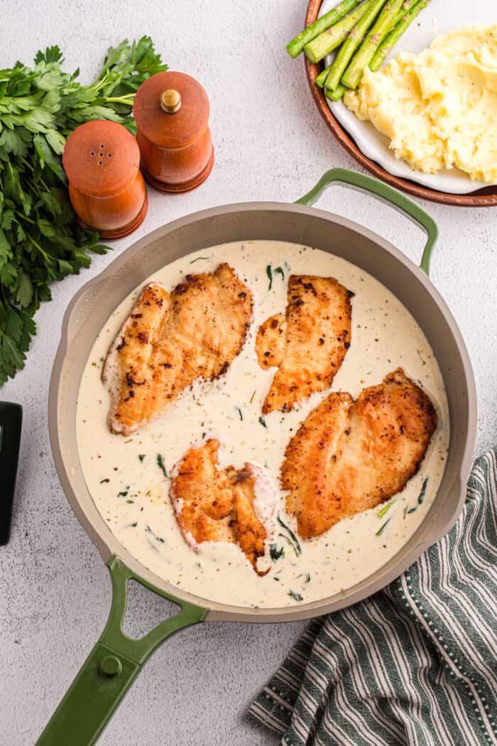 Juicy pan-fried chicken is coated in a creamy, garlicky white wine sauce with spinach and freshly grated parmesan in this Chicken Florentine. Chicken returned to the creamy sauce