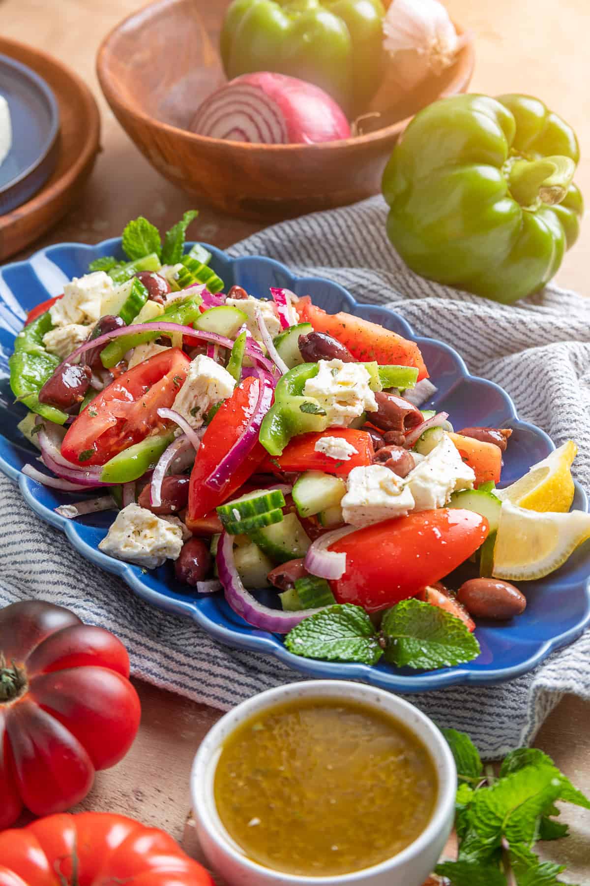 This traditional Greek Salad is made with simple ingredients & bold flavors, like fresh veggies, Kalamata olives, and feta cheese. Greek salad on a blue serving plate