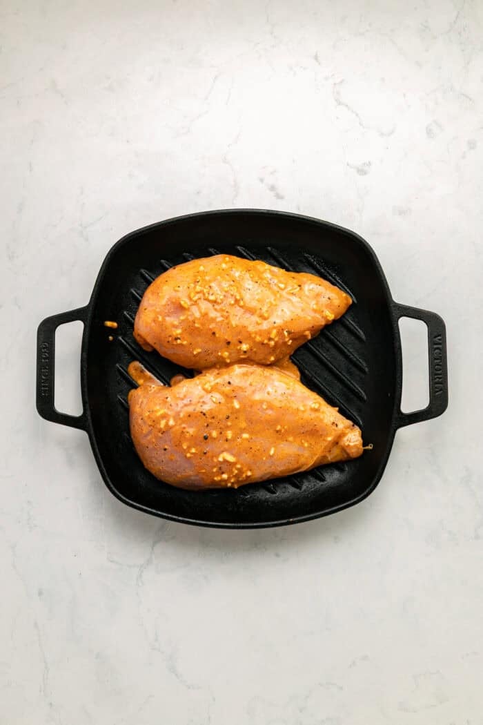Grilled chicken sits atop a bed of lettuce with cucumber, avocado, tomato, and sharp cheddar cheese in this Honey Mustard Chicken Salad. Marinated chicken breasts in a grill pan