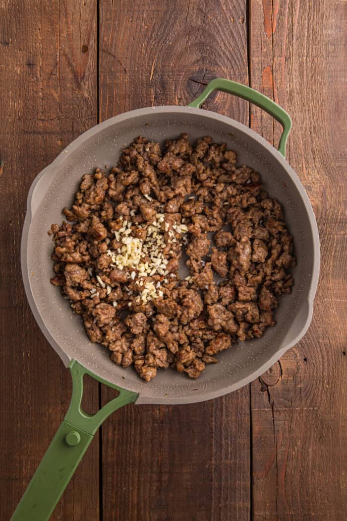 Italian Sausage Pasta is ready in just 30 minutes with a handful of ingredients. Creamy, decadent, and flavorful! Browned Italian sausage and garlic in a pan